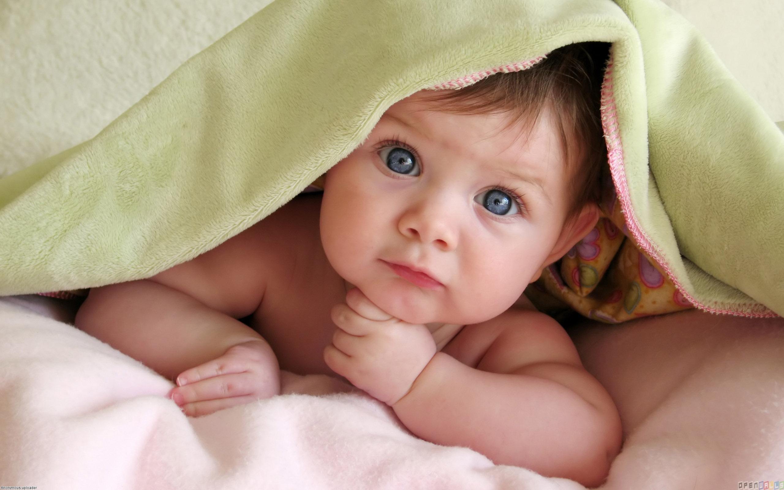 Cute Baby Girl in Bedsheet Wallpaper